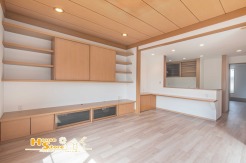 収納棚やテレビ台が備え付けられたリビングは、家具を新たに揃える必要がなく、すっきりと片付きます。木目調のデザインが温かみを演出し、家族が自然と集まる心地よい空間です。