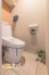 温水洗浄便座を備えた、快適で清潔感のあるトイレ空間。戸棚付きのため、トイレ用品をすっきり収納でき、空間を美しく保てます。